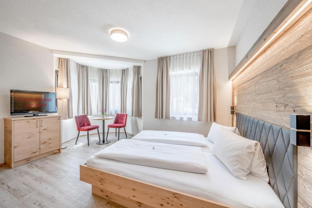 Habitación de hotel con cama grande y TV en Gasthof Schroll, en Kirchbichl