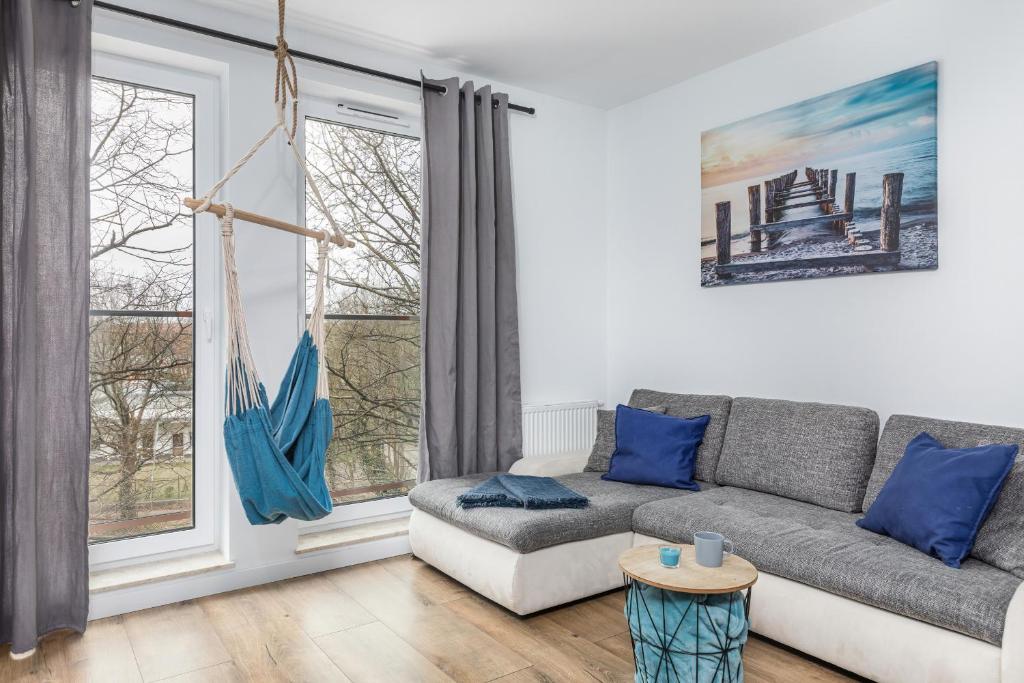 a living room with a couch and a window at Apartamenty Wyspa Solna by Renters in Kołobrzeg