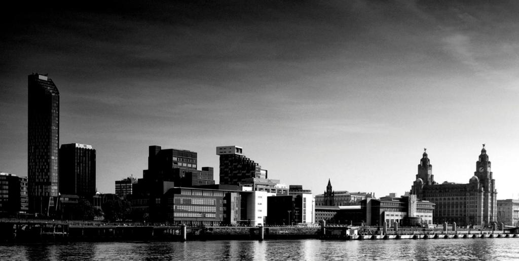 a city with tall buildings and a river at Royal Chambers Liverpool in Liverpool