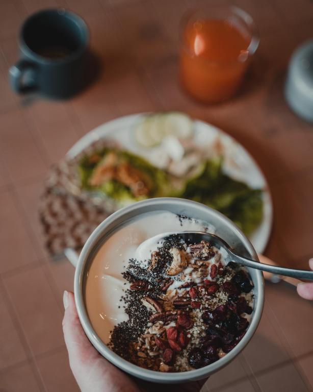 a person holding a bowl of food with a plate of food at VALO Hotel & Work Helsinki in Helsinki