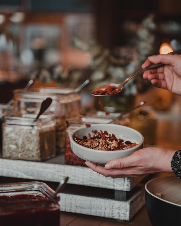a person holding a bowl of food with a spoon at VALO Hotel & Work Helsinki in Helsinki