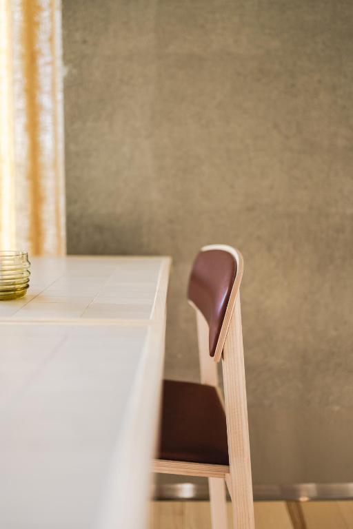 a wooden chair sitting next to a white desk at VALO Hotel & Work Helsinki in Helsinki