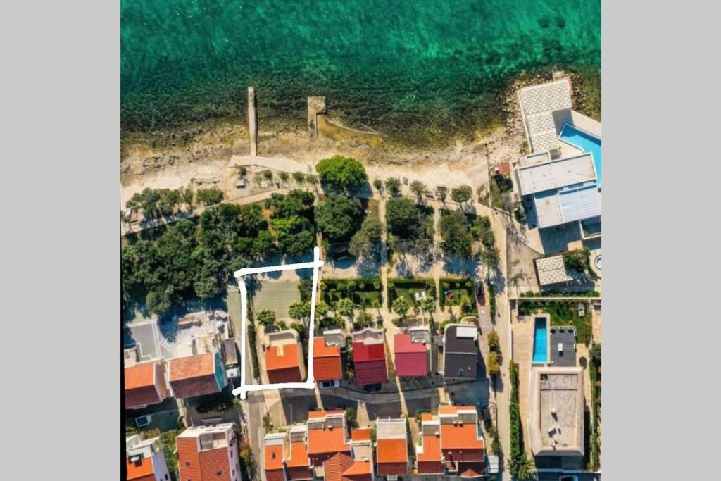 Apartment Punta skala Villa Valentina في بيتريتشاني: اطلالة جوية على شاطئ به بيوت ومحيط