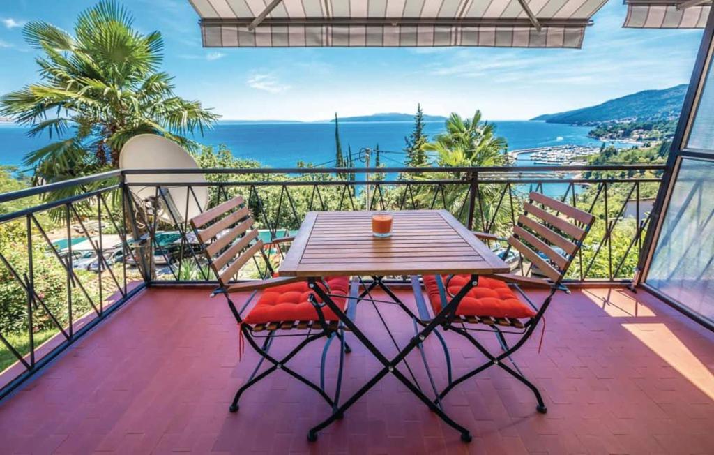 una mesa y sillas en un balcón con vistas al océano en Breathtaking sea view app for 2+1, BBQ ......, en Opatija