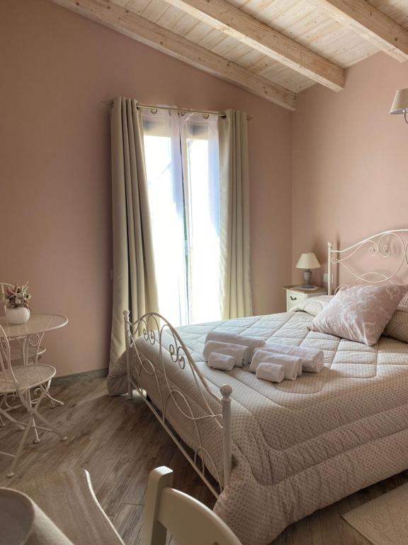una camera con un letto bianco e un tavolo di La Soffitta di EmmaSofia a San Vito