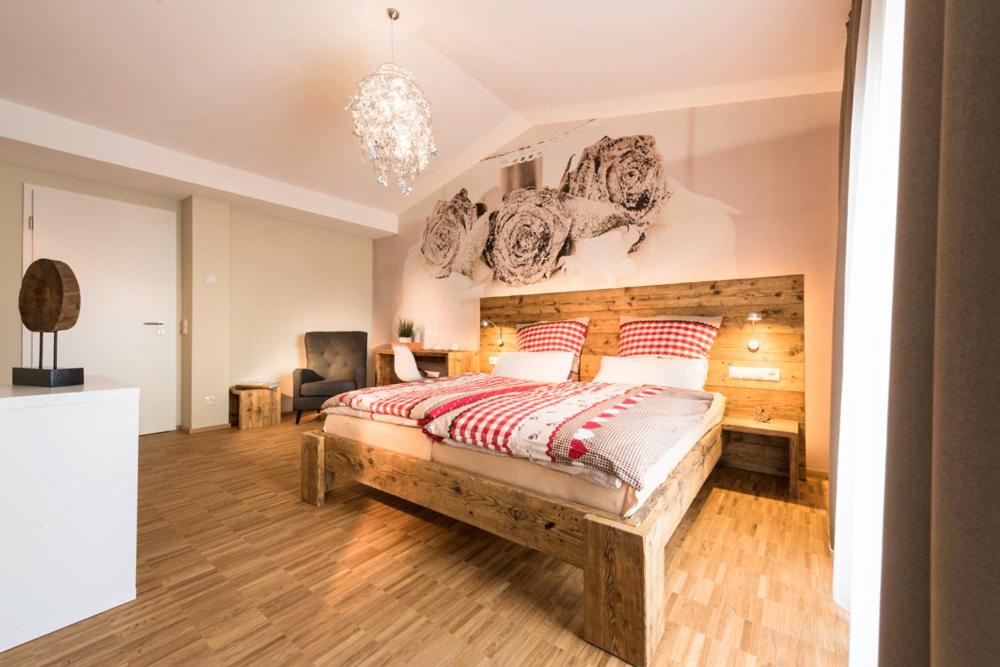 Schlafzimmer mit einem großen Bett mit einem Kopfteil aus Holz in der Unterkunft Webers "alte Backstube" in Friedrichshafen