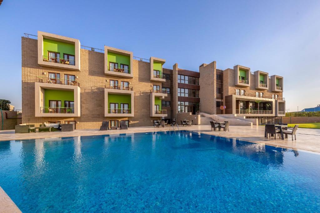 uma grande piscina em frente a um edifício em Dhara Residence E2 Lodge Hotel em Cidade 6 de Outubro