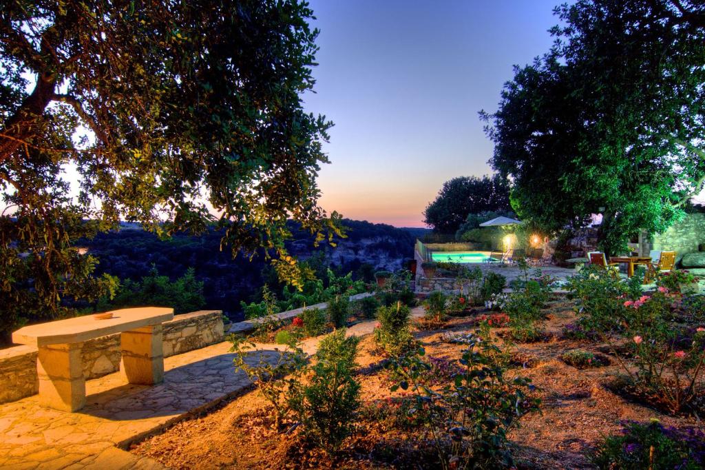 una panchina in un giardino al tramonto di Villa Nikolaos a Elefterna