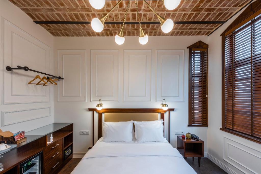 1 dormitorio con 1 cama, escritorio y ventanas en PeraNox Boutique Hotel, en Estambul