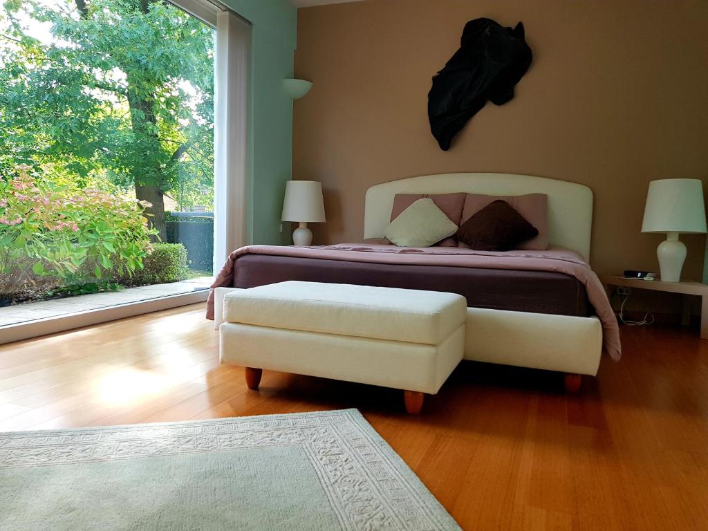 a bedroom with a bed and a chair and a window at B&B prince d’Orange Waterloo in Waterloo