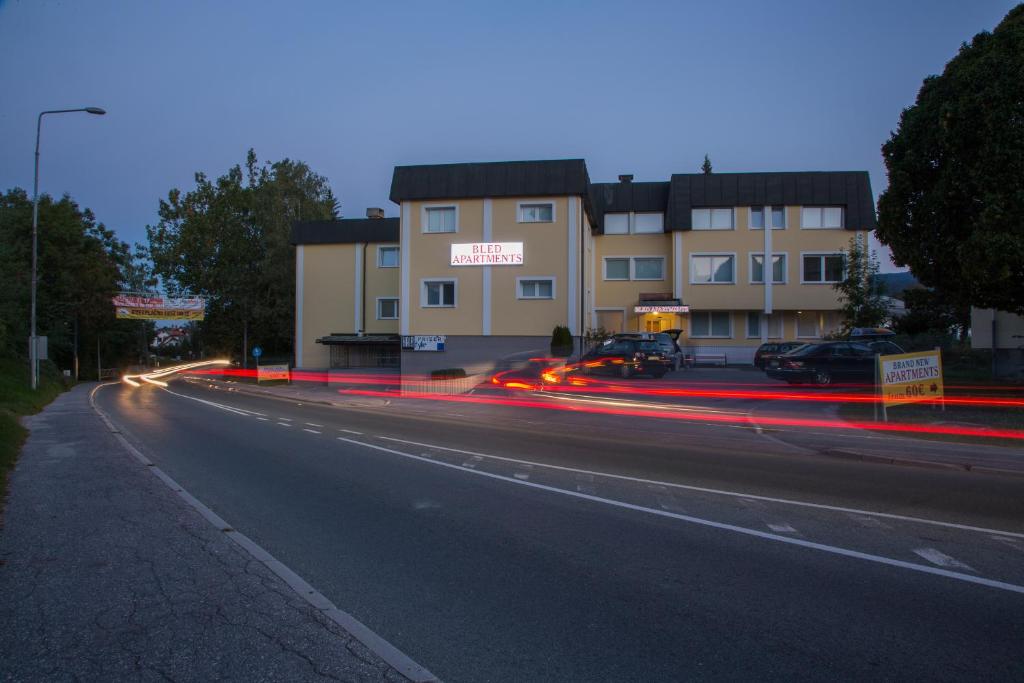 una calle de la ciudad con coches pasando un edificio en Apartments Benedičič, en Bled