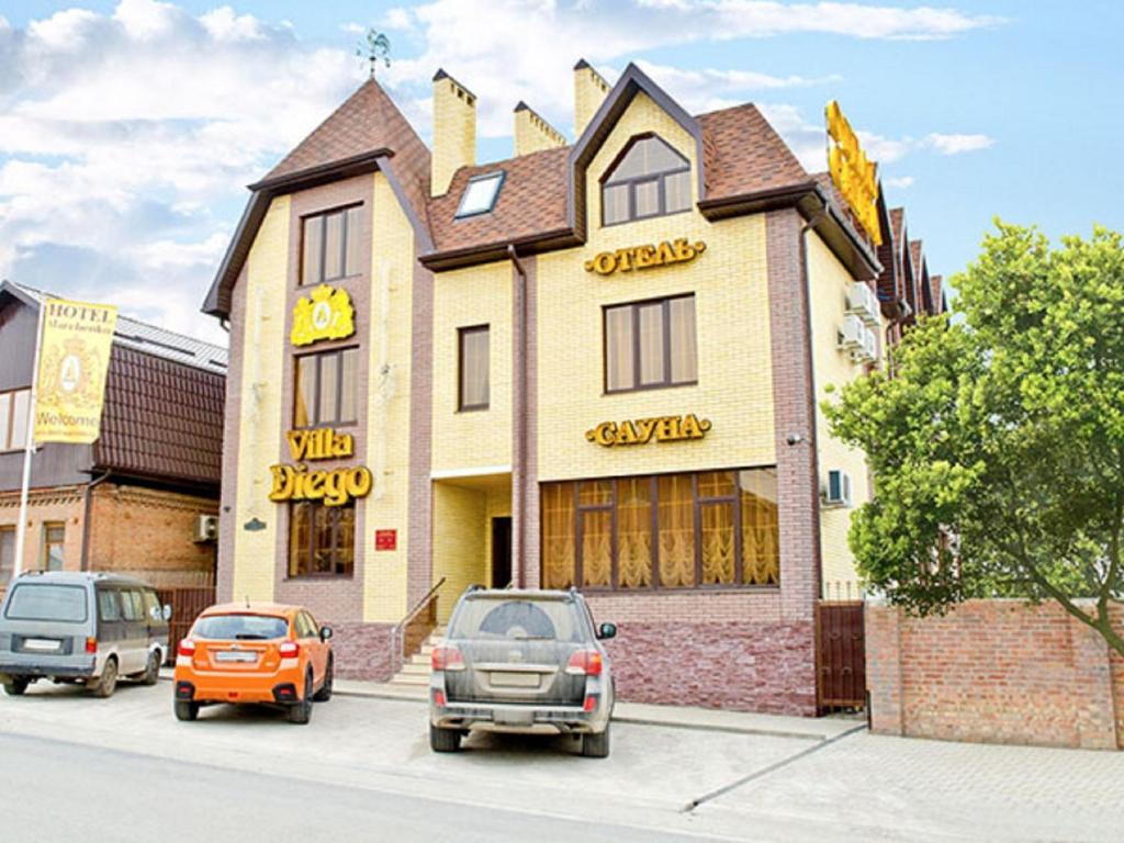 a building with cars parked in front of it at Villa Diego in Rostov on Don