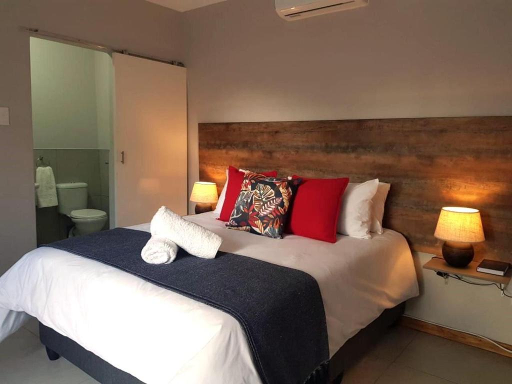 1 dormitorio con 1 cama blanca grande con almohadas rojas en MediStay, en Bethlehem