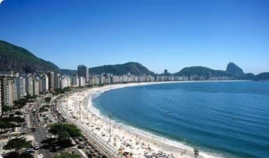 una playa con un grupo de edificios y el océano en No Coração de COPACABANA, en Río de Janeiro