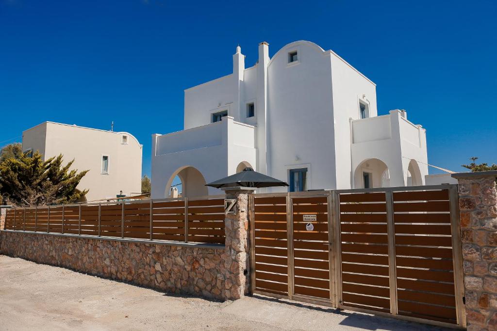 une clôture en bois devant un bâtiment blanc dans l'établissement The Z Private Villa, Santorini, à Monolithos