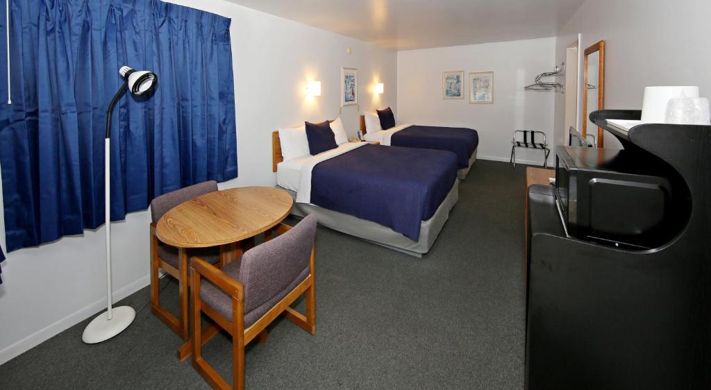 a hotel room with a bedroom with a bed and a table at Aurora Borealis in Saint Ignace