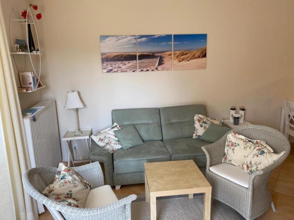 uma sala de estar com um sofá e duas cadeiras em Ferienwohnung Strandkorb em Scharbeutz