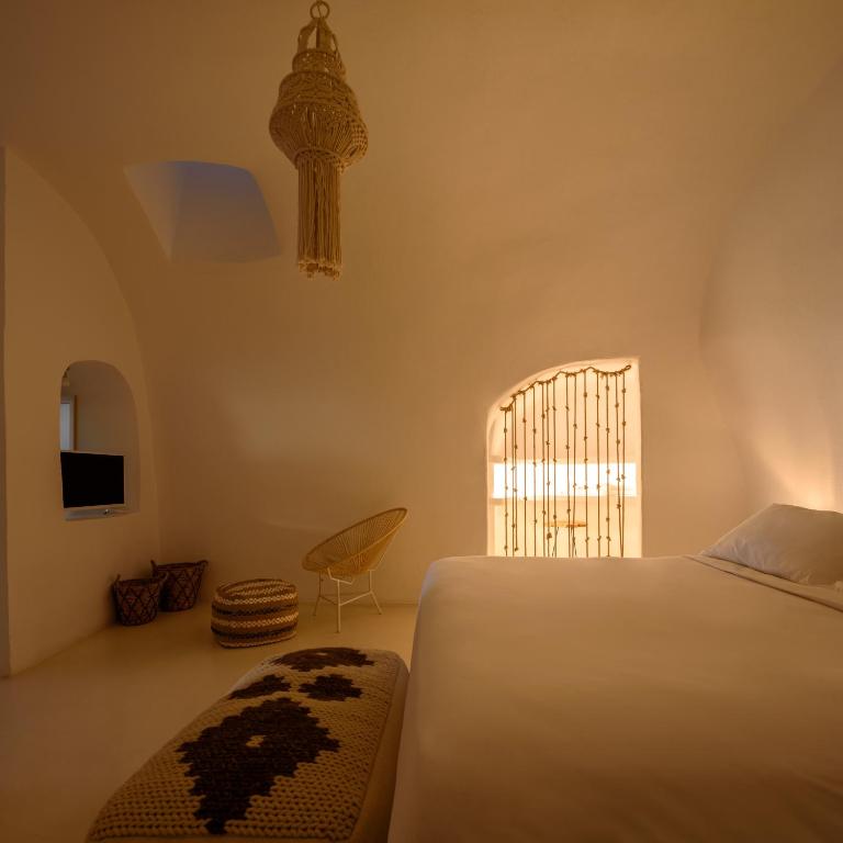 a bedroom with a bed and a window at Suite Home Santorini in Fira