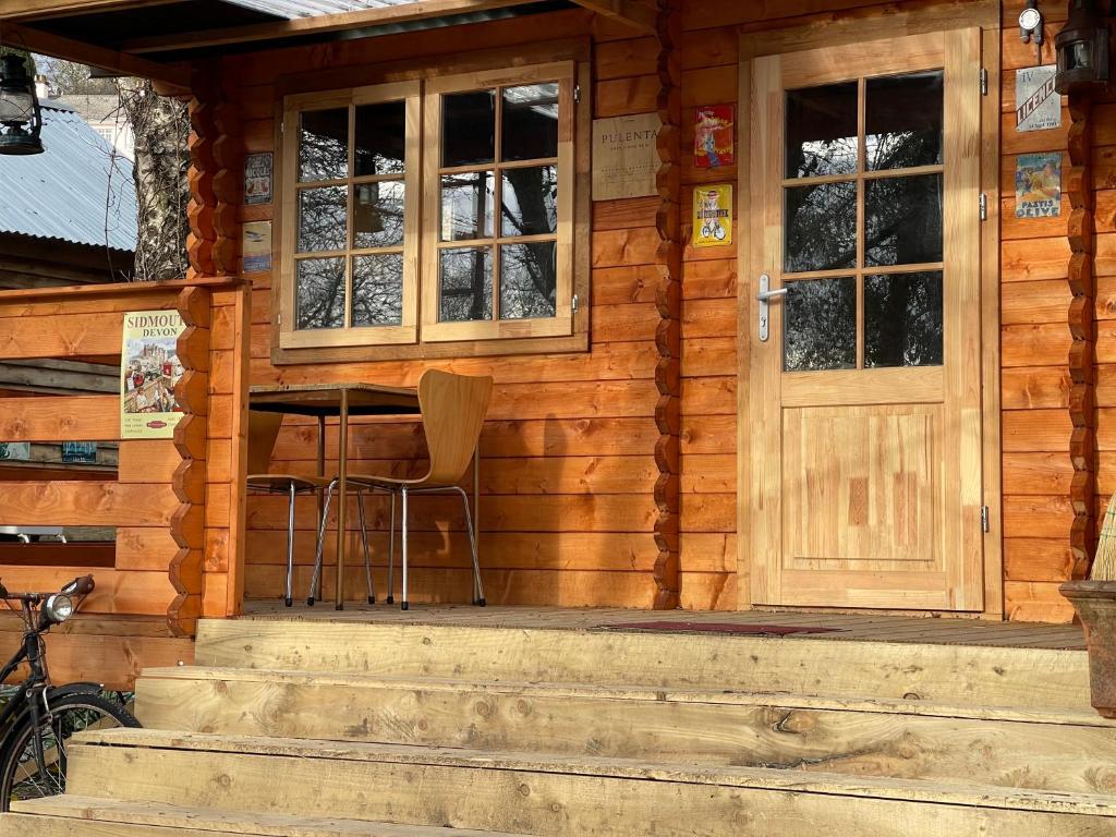 een houten hut met een deur en een stoel op de veranda bij Retro private Lodge with hot tub Nr Dartmoor in Newton Abbot