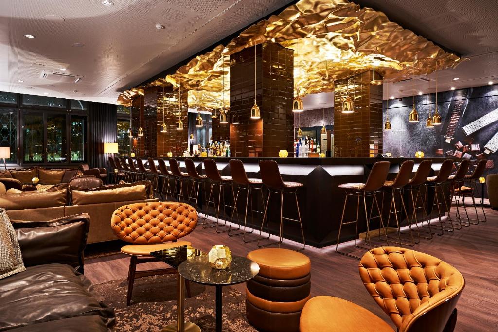 a bar with leather furniture and a bar counter at Motel One Zürich in Zürich