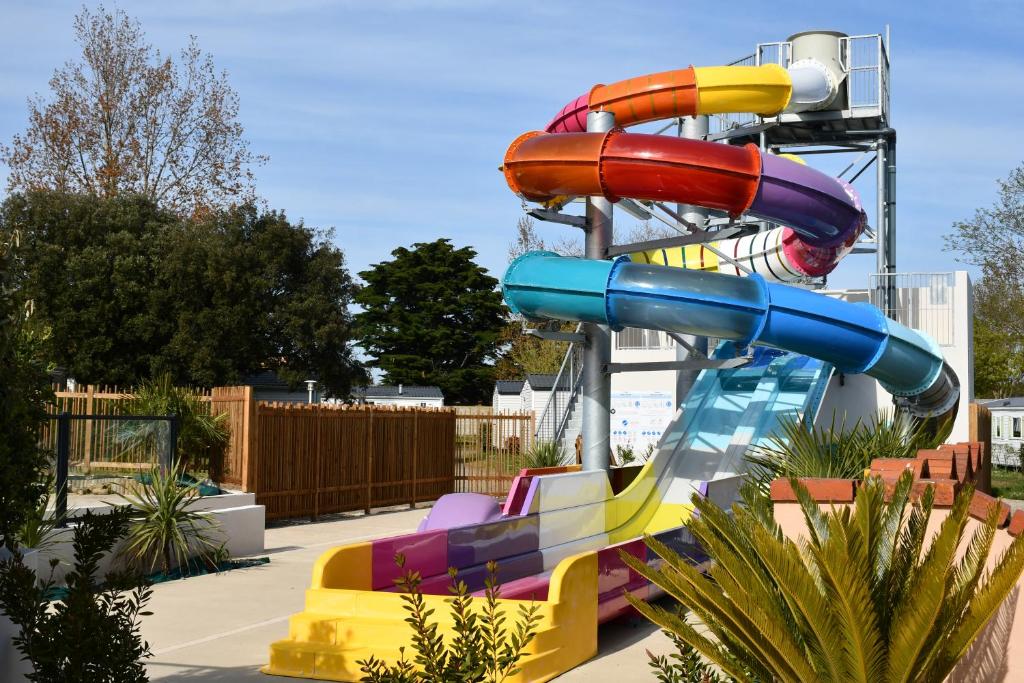 a water slide in a park with a colorful slide at Camping Le Puits Rochais in Les Sables-dʼOlonne