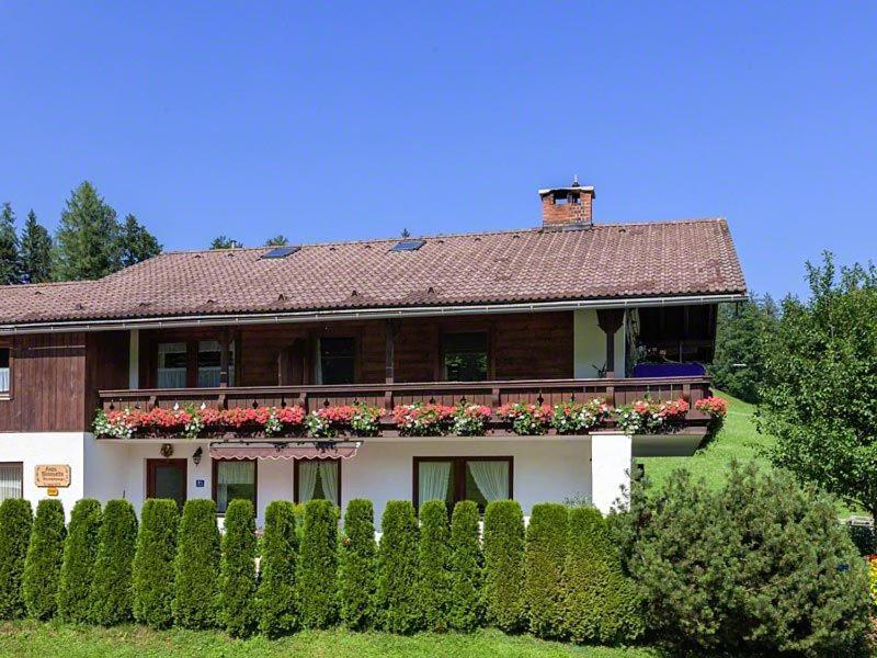 uma casa grande com flores em frente a uma cerca em Ferienwohnungen Haus Sonnseitn em Berchtesgaden