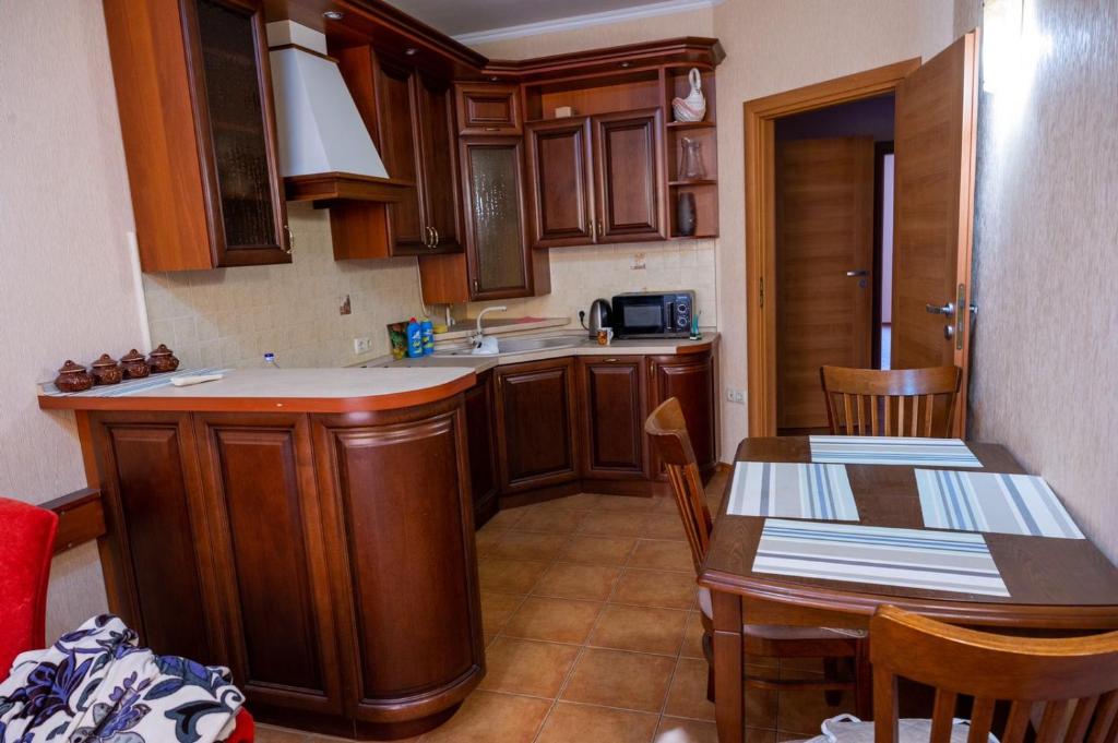 a kitchen with wooden cabinets and a table and chairs at Apartment Lazurna 2 41 in Chornomorsk