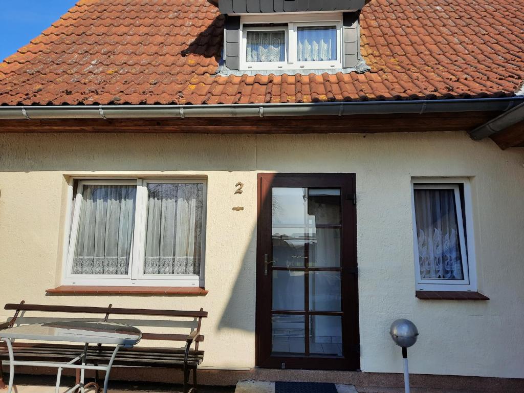 a house with a table and a bench in front of it at Moritz - Ferienhaus östlich der Dorfstraße in Grieben Insel Hiddensee in Grieben