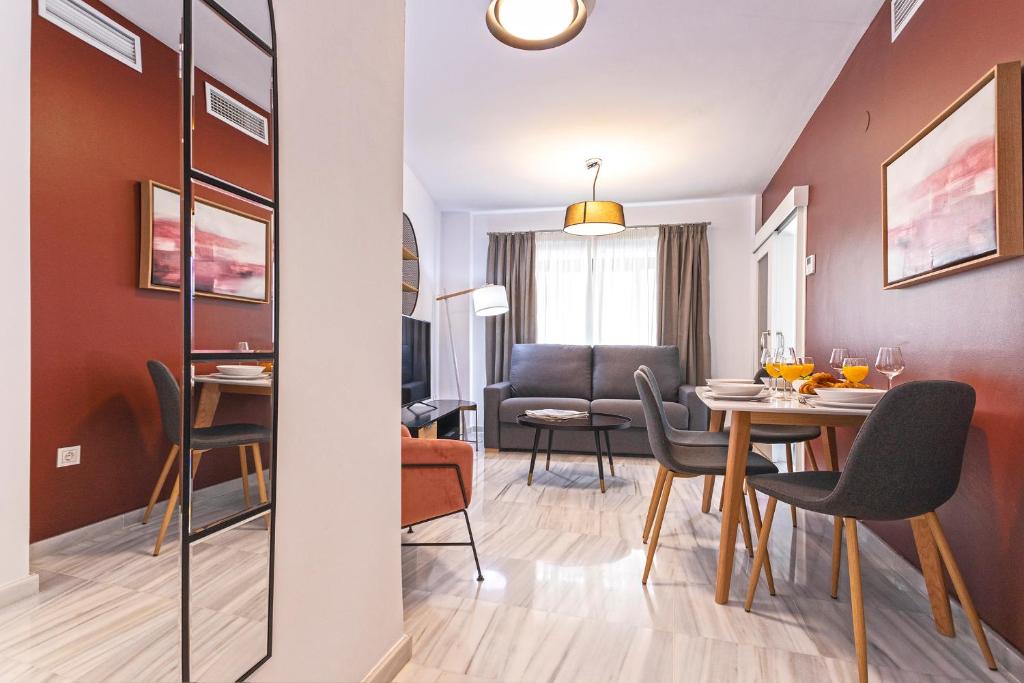 comedor y sala de estar con mesa y sillas en Málaga Rivas 34 Suites Homes, en Málaga