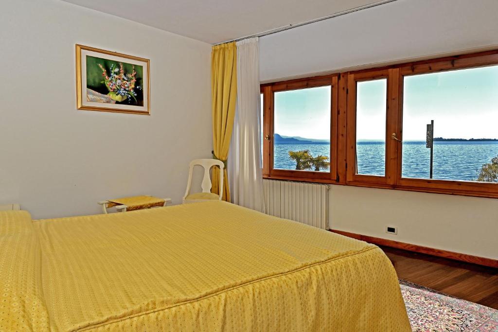 una camera con letto giallo e finestra di Camere Al Veliero a Gardone Riviera