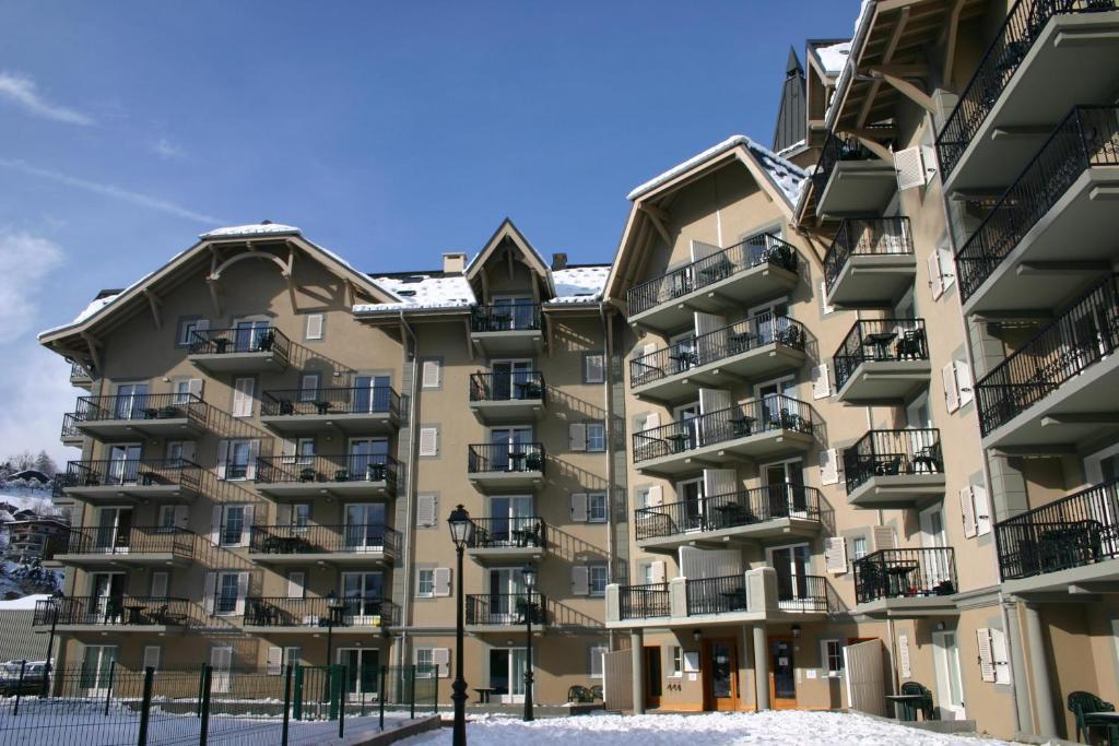 un grand immeuble avec de la neige au sol dans l'établissement Appartement 6 personnes Grand Panorama, à Saint-Gervais-les-Bains