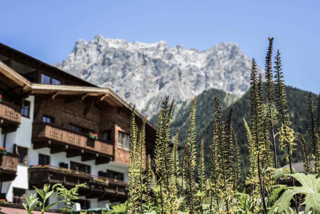 a view of a hotel with a mountain in the background at Hotel Tirolerhof - Familotel Zugspitze in Ehrwald