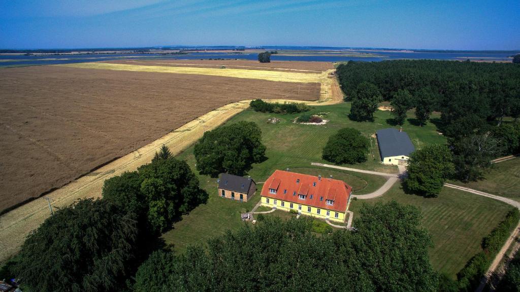 eine Luftansicht eines großen Hauses mit rotem Dach in der Unterkunft Ferienhaus Gut Rattelvitz Insel Rügen in Gingst