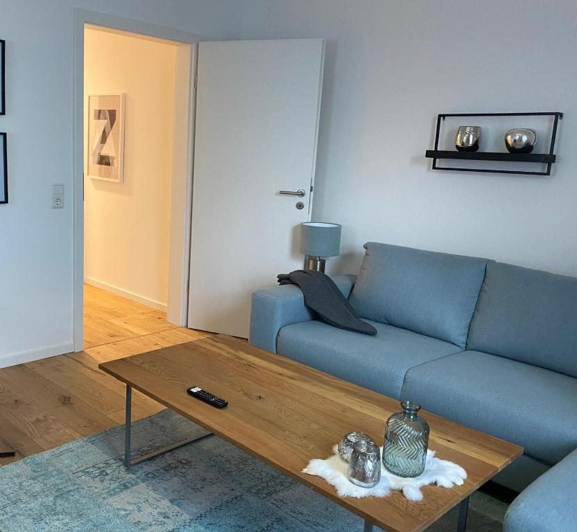 a living room with a blue couch and a coffee table at ZEITraum1 Gummersbach in Gummersbach