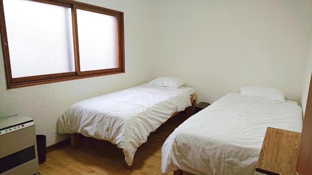 Postel nebo postele na pokoji v ubytování Kawayu Onsen Guesthouse NOMY
