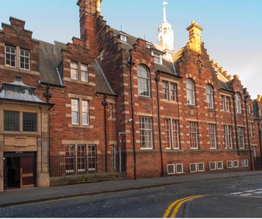 a large red brick building on a street at Beautiful 1-Bed Apartment near Castle in Edinburgh
