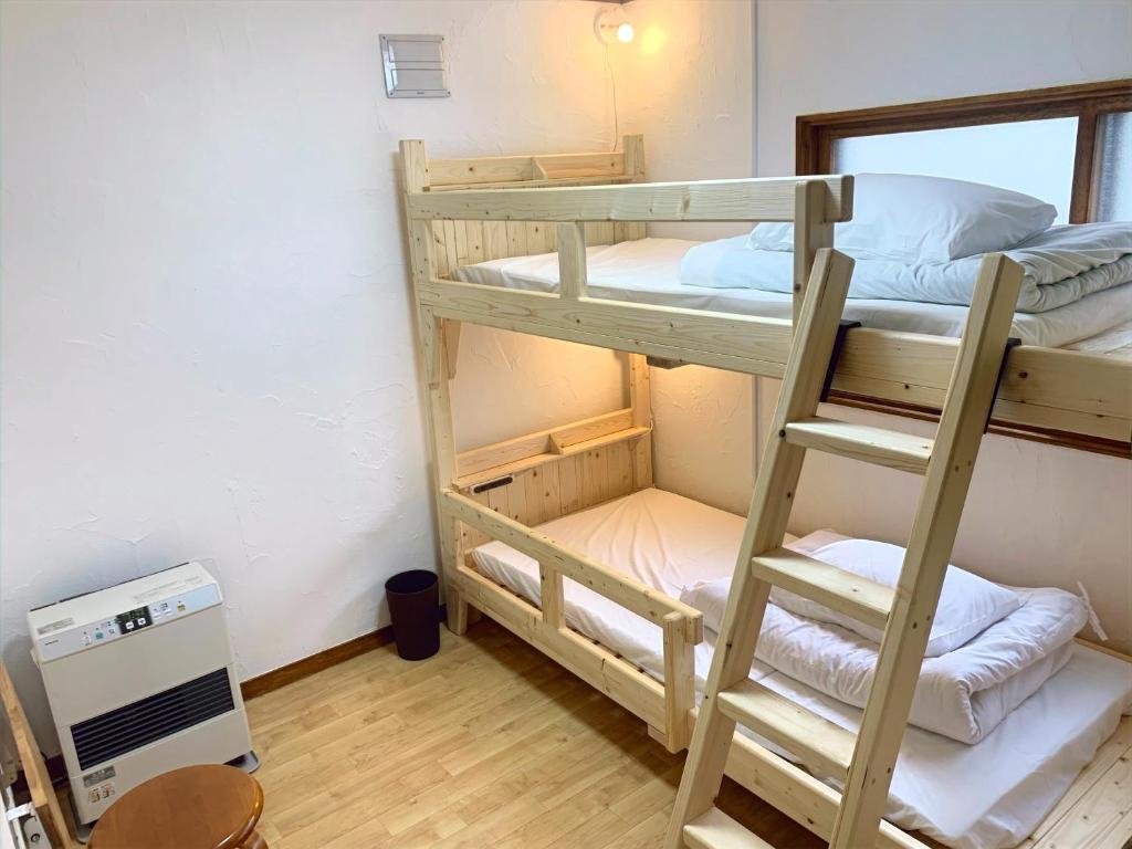 Postel nebo postele na pokoji v ubytování Kawayu Onsen Guesthouse NOMY