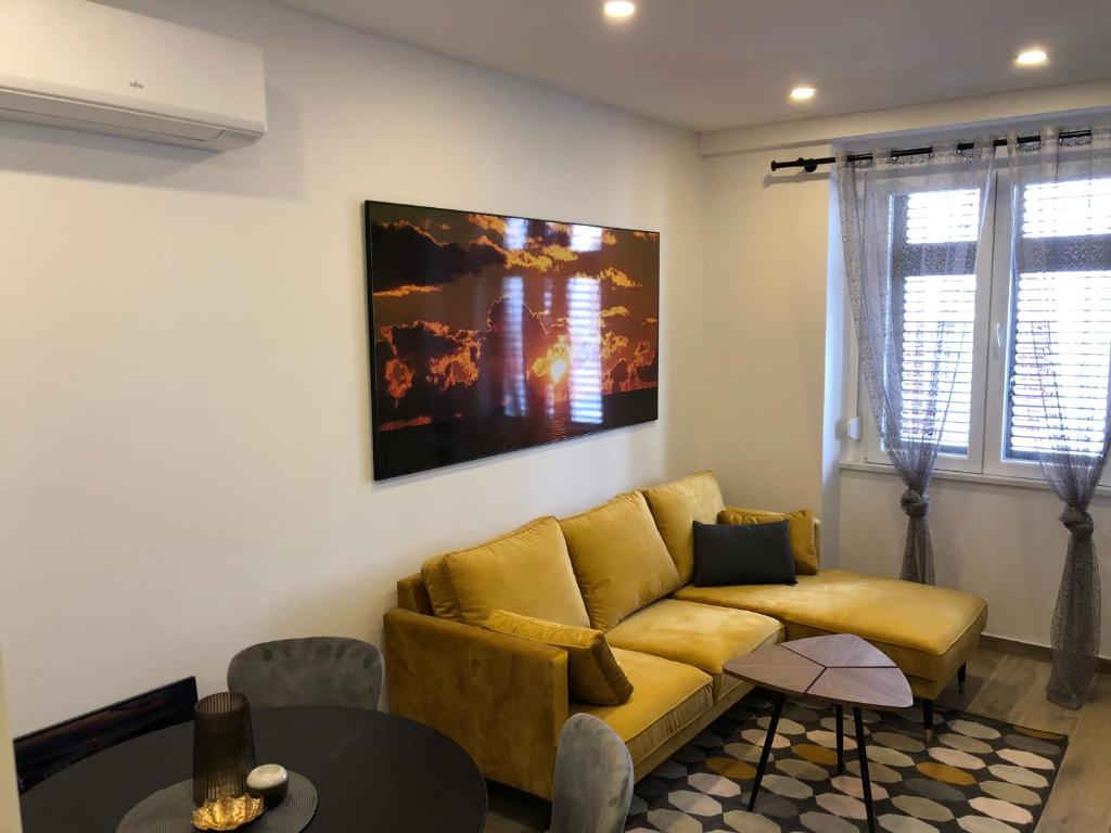 a living room with a yellow couch and a table at Apartment MAK with free parking in Pula