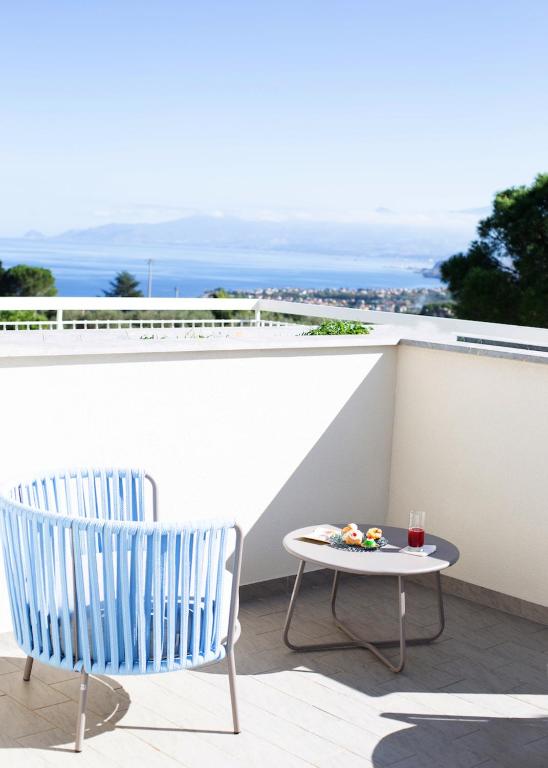two chairs and a table on a balcony at Principe Alogna Hotel & SPA in Altavilla Milicia