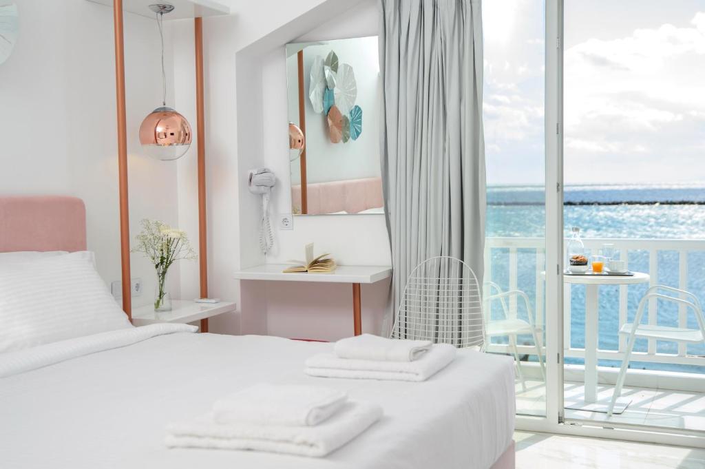 sypialnia z łóżkiem i widokiem na ocean w obiekcie Nama Boutique Hotel w mieście Tinos