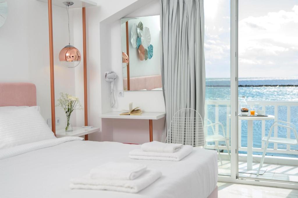 a bedroom with a bed and a view of the ocean at Nama Boutique Hotel in Tinos Town