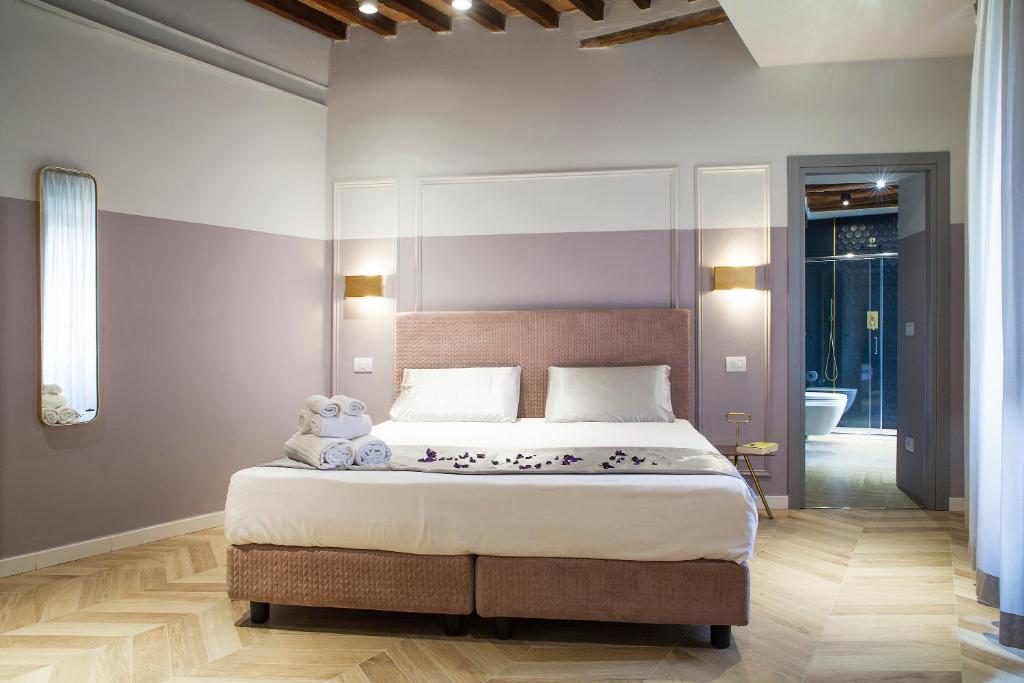 a bedroom with a bed with a teddy bear on it at San Sebastiano Suite & Luxury Apartments in Colle di Val d'Elsa