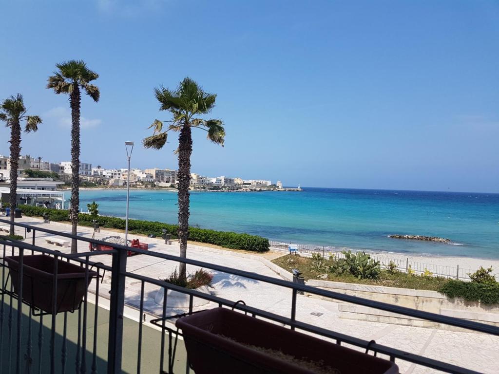 a view of a beach with palm trees and the ocean at Hotel Profumo Di Mare in Otranto