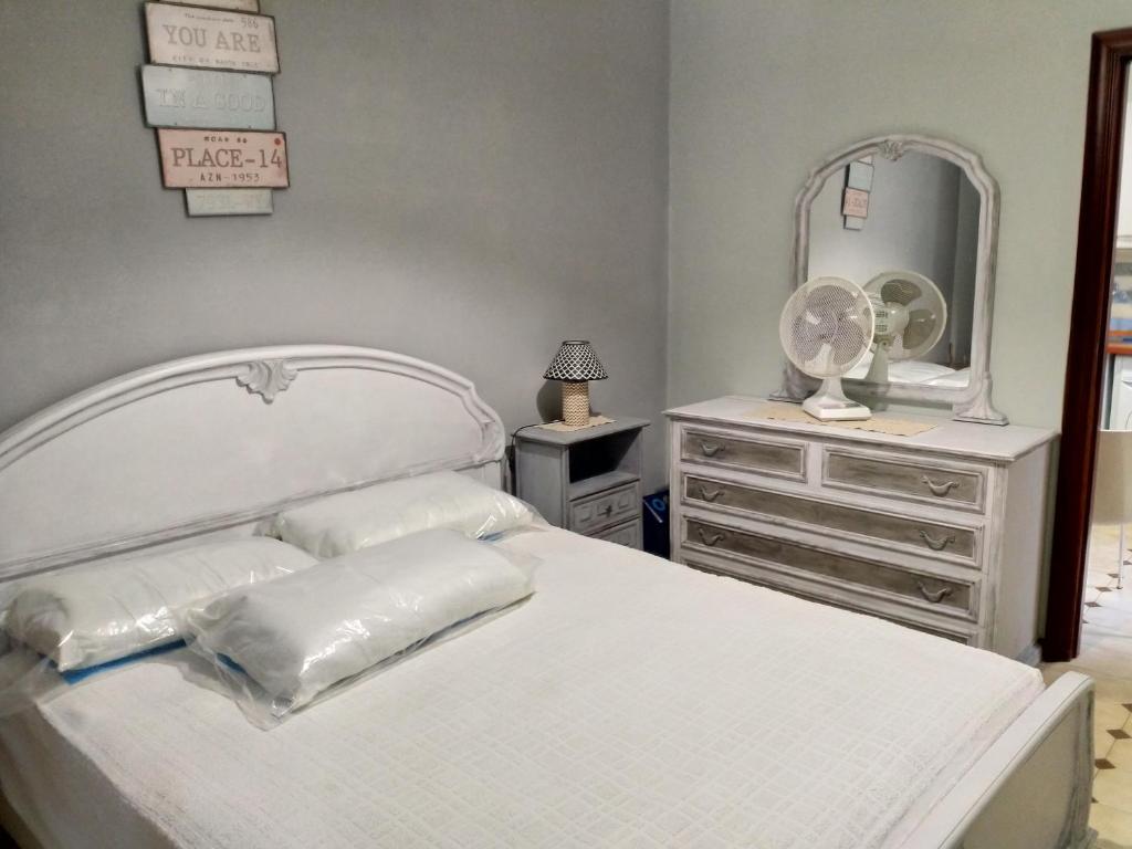 biała sypialnia z białym łóżkiem i lustrem w obiekcie Gioscy w mieście Citta' Sant'Angelo