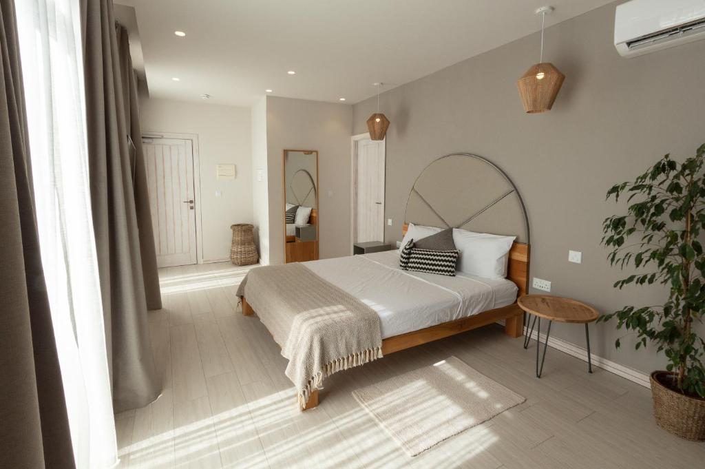 a bedroom with a large bed and a plant at Villa dei Venti in Qala
