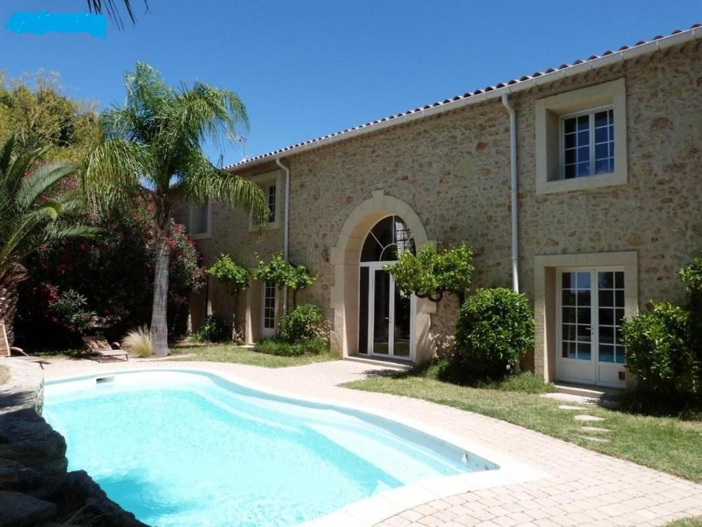 une maison avec une piscine en face de celle-ci dans l'établissement Chambres d'hôtes la Soulenque Luxury B & B, à Capestang