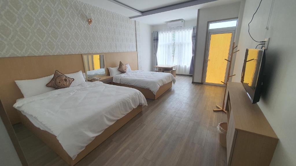 a hotel room with two beds and a flat screen tv at Thành Mỹ Hotel in Cam Ranh