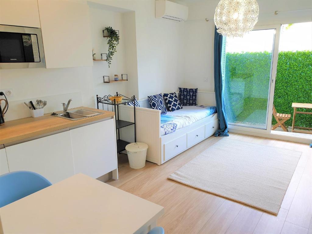 Il dispose d'une cuisine et d'un salon avec un canapé et une fenêtre. dans l'établissement Promenade proche mer 01, à Nice