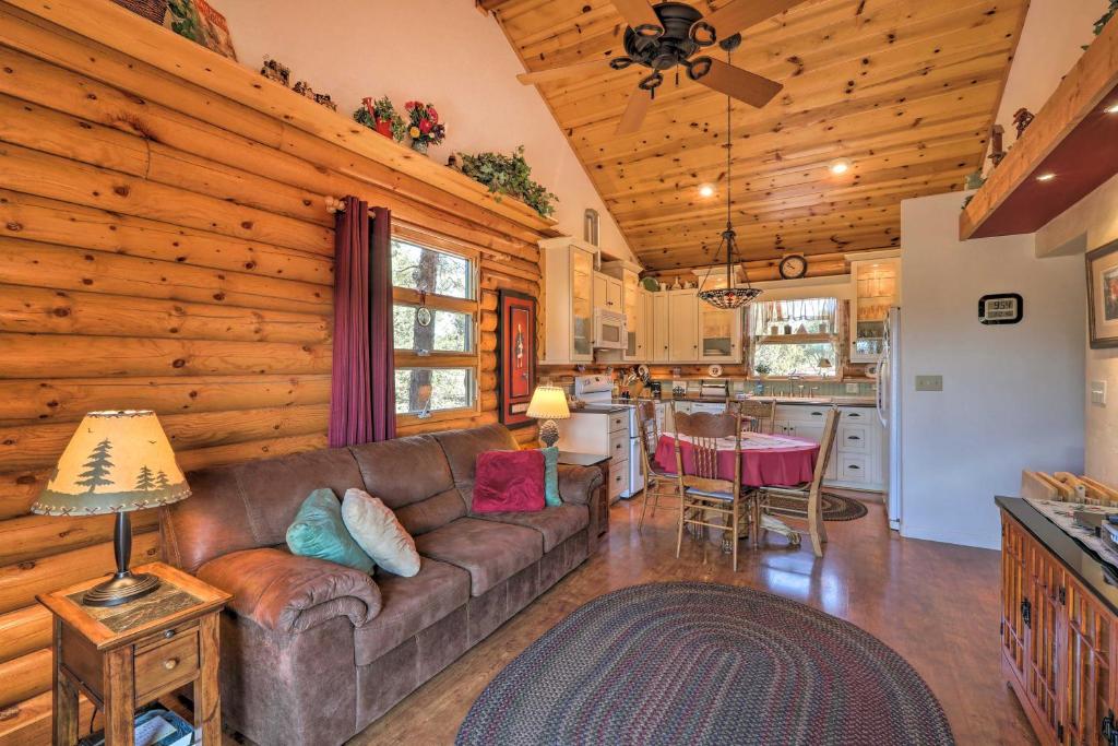 a living room with a couch and a kitchen at Quaint Williams Cabin Near Grand Canyon in Williams