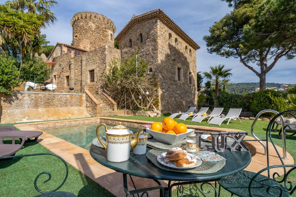 uma mesa com uma taça de fruta e um castelo em Castillo Can Xirau, Propiedad Exclusiva con piscina & aircon em Santa Susanna